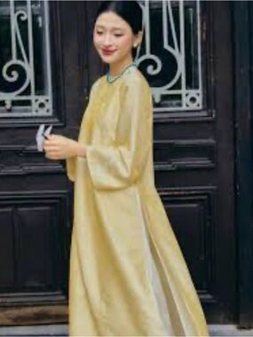 HOAN GVU yellow traditional Vietnamese Áo dài with a subtle textured pattern.